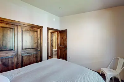 a bedroom with a white bed and a wooden door at Arrowhead Adventures in South Lake Tahoe