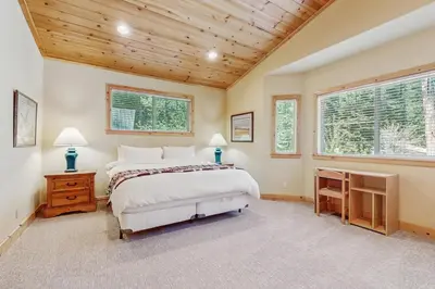 a bedroom with a large bed and two windows at Willow Creek Hideway in Tahoma