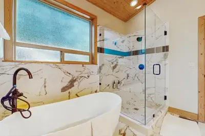 a bathroom with a tub and a shower at Willow Creek Hideway in Tahoma