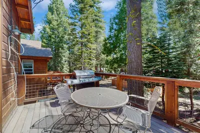 a table and chairs on a deck with a grill at Willow Creek Hideway in Tahoma