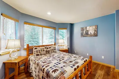 a bedroom with a bed with blue walls and windows at Cochise Adventures in South Lake Tahoe
