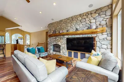 a living room with couches and a stone fireplace at Cochise Adventures in South Lake Tahoe