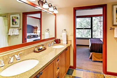 a bathroom with two sinks and a large mirror at Resort at Squaw Creek's 556, 558, & 560 in Olympic Valley