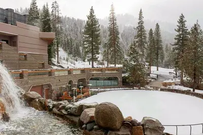 a snow covered pool in front of a building with a waterfall at Resort at Squaw Creek's 556, 558, & 560 in Olympic Valley