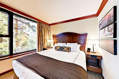 a bedroom with a large bed and two windows at Resort at Squaw Creek's 556, 558, & 560 in Olympic Valley