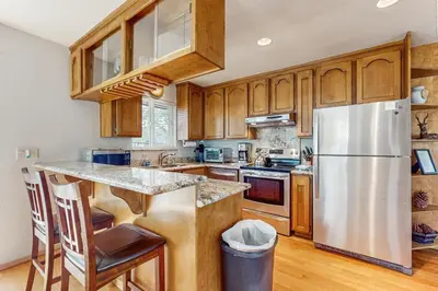 a kitchen with wooden cabinets and a stainless steel refrigerator at Azure Palace in South Lake Tahoe