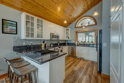 a kitchen with white cabinets and a wooden ceiling at Heaven by the Lake in Truckee