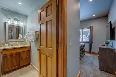 a bathroom with a wooden door and a sink at Heaven by the Lake in Truckee