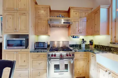 a kitchen with wooden cabinets and a stove top oven at Cottage Charms in South Lake Tahoe