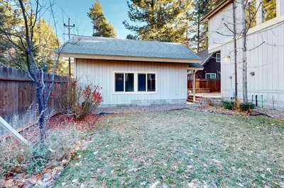 a small white house with a fence and a yard at Cottage Charms in South Lake Tahoe