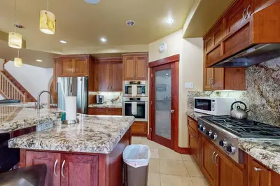 a kitchen with wooden cabinets and a stove top oven at Cherry Hill Charms in South Lake Tahoe