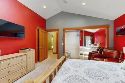 a bedroom with red walls and a bed and a couch at Cherry Hill Charms in South Lake Tahoe