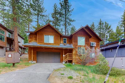 a wooden house with a garage in a yard at Jacarillo Escape in South Lake Tahoe