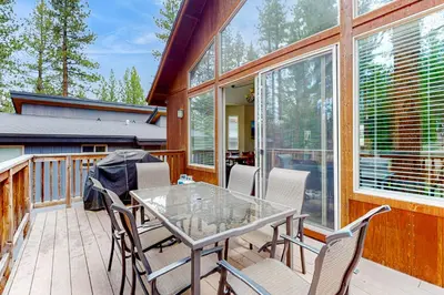 a patio with a glass table and chairs on a deck at Jacarillo Escape in South Lake Tahoe