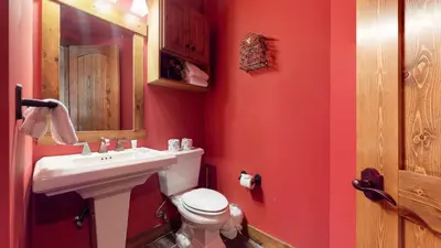 a red bathroom with a sink and a toilet at Snowcreek VI The Lodges #1133 condo in Mammoth Lakes