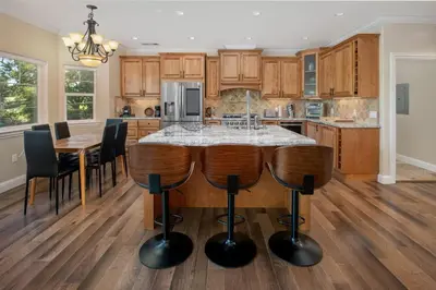 a kitchen with a island in the middle of a table at New Luxury 5BR Cabin in Pine Mountain Lake! 1 Minute to Beach! Massage Chair! Close to Yosemite! Perfect for Retreats and Escapes All Seasons! in Groveland