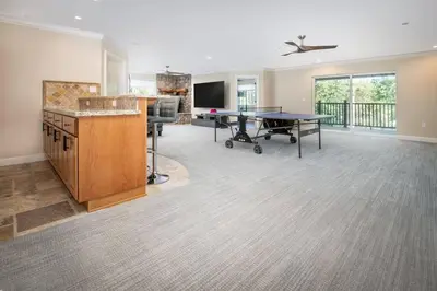 a living room with a ping pong table in the middle at New Luxury 5BR Cabin in Pine Mountain Lake! 1 Minute to Beach! Massage Chair! Close to Yosemite! Perfect for Retreats and Escapes All Seasons! in Groveland