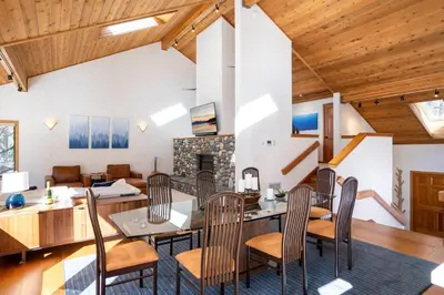 a dining room and living room with wood ceilings at Creekside at Northstar home in Truckee