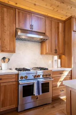 a kitchen with a stainless steel stove and wooden cabinets at Creekside at Northstar home in Truckee