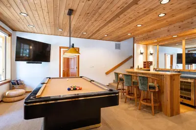 a pool table in a room with a bar at Creekside at Northstar home in Truckee