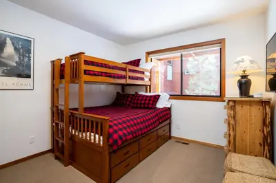 a bedroom with a bunk bed and a window at Creekside at Northstar home in Truckee