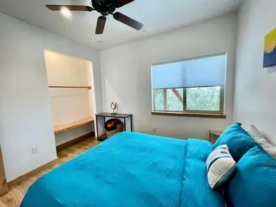 a bedroom with a blue bed and a ceiling fan at Ravens Lair in Yosemite West