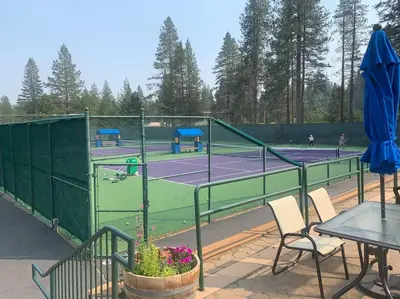 a tennis court with a table and chairs on a tennis court at Fully updated Truckee cabin with plenty of beds in Truckee