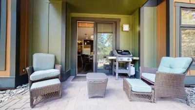 a patio with chairs and a grill on a house at Solstice #14 condo in Mammoth Lakes