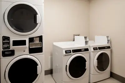 two washing machines and a dryer in a room at Holiday Inn Express & Suites - Hollister by IHG in Hollister