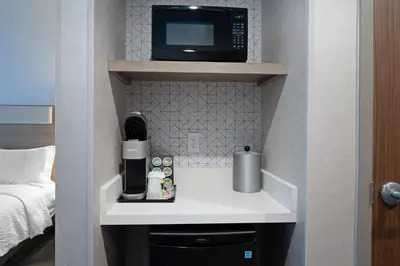a microwave sitting on top of a shelf in a room at Holiday Inn Express & Suites - Hollister by IHG in Hollister