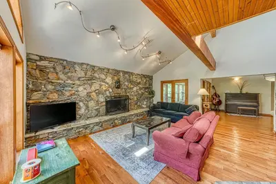 a living room with a stone wall with a fireplace at Cascadel Haven in North Fork