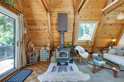 a living room with a fireplace in a log cabin at Decks, Grills and Fire Pit Camp Connell Hideaway! in Camp Connell