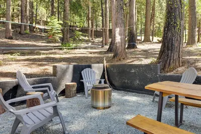 a fire pit with chairs and a tea kettle at Decks, Grills and Fire Pit Camp Connell Hideaway! in Camp Connell