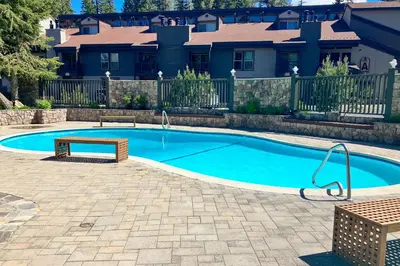 a swimming pool with a bench in front of a house at Chamonix 6 in Mammoth Lakes