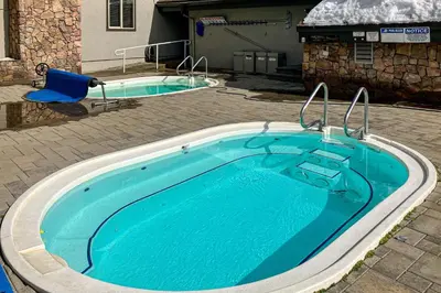 a swimming pool in a yard with a blue chair at Chamonix 6 in Mammoth Lakes
