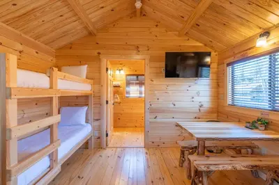a log cabin with a bunk bed and a table at Casa de Fruta Cabins, Inn & RV Park in Hollister