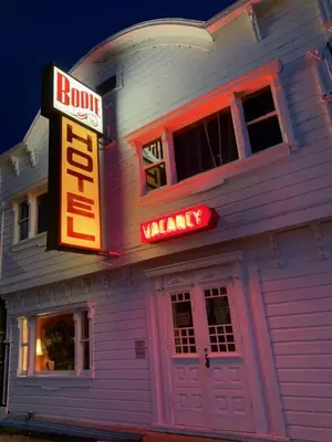 a building with a neon sign and a building with at The Bodie Hotel in Bridgeport
