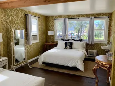 a bedroom with two beds and a mirror at The Bodie Hotel in Bridgeport
