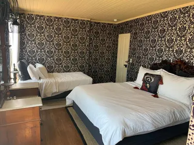 a bedroom with two beds and a wall at The Bodie Hotel in Bridgeport