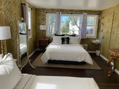 a bedroom with a large white bed and a window at The Bodie Hotel in Bridgeport