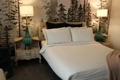 a bedroom with a large white bed with two lamps at The Bodie Hotel in Bridgeport