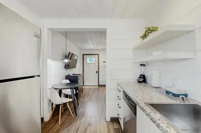 a white kitchen with a counter and a table at Manzanita Holiday 3 in South Lake Tahoe