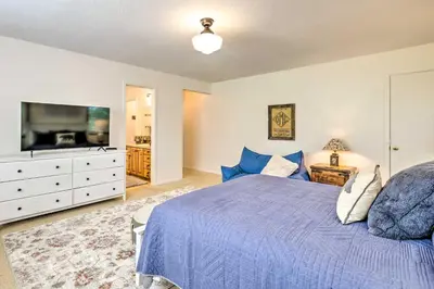 a bedroom with a blue bed and a flat screen tv at Steps to Dtwn Murphys Cottage with Furnished Porch in Murphys