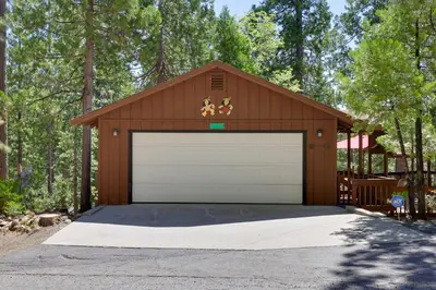 a brown garage with a white garage door at Furnished Deck High Sierra Cabin in Twain Harte! in Twain Harte