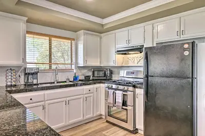 a kitchen with white cabinets and a stainless steel refrigerator at Balcony and Scenic View Sonora Hideaway! in Sonora