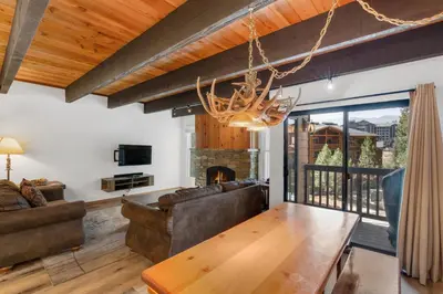 a living room with a table and a fireplace at Val D'Isere at the Village by 101 Great Escapes in Mammoth Lakes