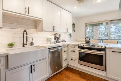 a kitchen with white cabinets and stainless steel appliances at Chamonix 24 is a 2bed plus loft 3 bath Upgraded Canyon Ldge Nearly Ski in Ski Out Sleeps 8 in Mammoth Lakes