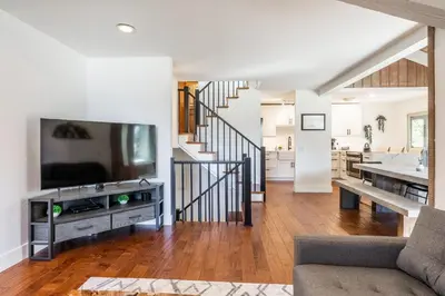 a living room with a television and a staircase at Chamonix 24 is a 2bed plus loft 3 bath Upgraded Canyon Ldge Nearly Ski in Ski Out Sleeps 8 in Mammoth Lakes