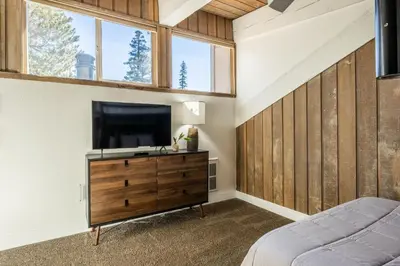 a bedroom with a tv on a dresser with a bed at Chamonix 24 is a 2bed plus loft 3 bath Upgraded Canyon Ldge Nearly Ski in Ski Out Sleeps 8 in Mammoth Lakes