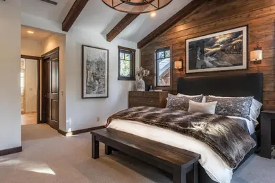 a bedroom with a large bed and a wooden wall at Gray Bear #86 home in Mammoth Lakes